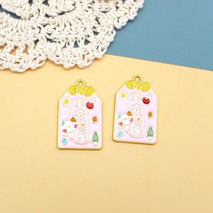 Detailansicht von rosa Omamori-Anhängern aus Legierung mit einem Glückskatzen-Motiv