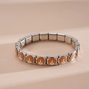 Primo piano del bracciale italiano in acciaio inossidabile con ciondoli smaltati di cane.