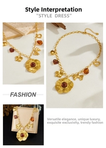 Close-up view of a gold-plated stainless steel necklace with resin charms and flower pendant.