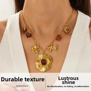 Macro view of vintage gold-plated necklace with bow, flower and heart charms