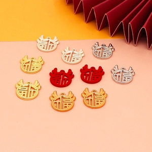Close-up of Fu character pendants in gold, silver and red alloy for DIY jewelry