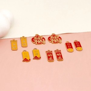 Detail view of various red and gold alloy enamel lucky charms for DIY jewelry.