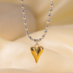 Close-up of a two-tone titanium steel necklace featuring gold heart and silver beads