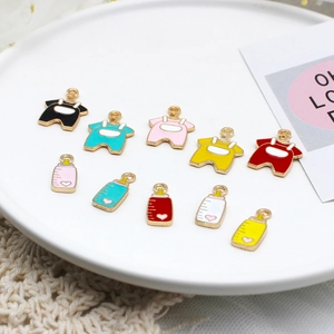 Macro view of colorful enamel baby bottle and clothing charms for DIY jewelry making.