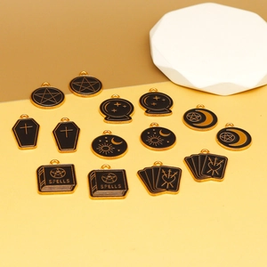 Detailed macro view of gothic tarot enamel charms with gold edges and black oil filling
