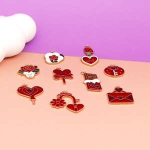 Detail of red and gold enamel Valentine's Day charms with heart and rose motifs.