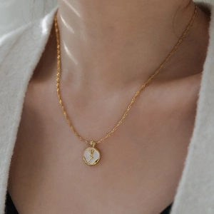 Élégant collier rose dorée et nacre pour femme porté par un mannequin sur du blanc