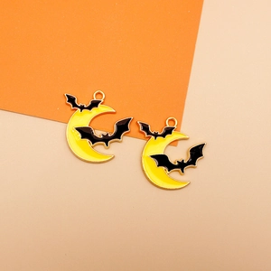 Macro detail of Halloween charms featuring black bats on a vibrant yellow crescent moon