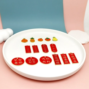 Detail shot of red alloy charms with Chinese blessing characters on a white plate
