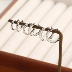 Close-up of S925 sterling silver earrings showing irregular hammered texture details