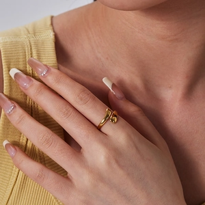 Close-up of a 18K gold-plated teardrop open ring on a finger with a polished finish
