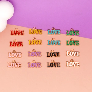 Detailed macro view of various colorful alloy drip oil LOVE letter charms for DIY jewelry making.