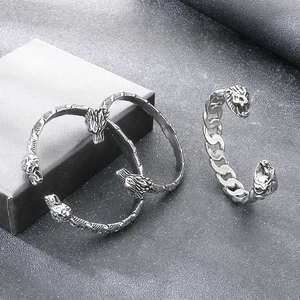 Detalle del brazalete punk vintage de acero de titanio con cabeza de león y serpiente para hombre.