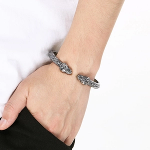 Detalle de brazalete punk de cabeza de león en acero de titanio retro en la muñeca