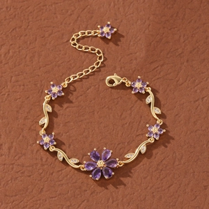 Detailed close-up of gold flower bracelet with purple gemstones and adjustable clasp