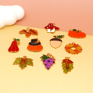 Collection of Thanksgiving enamel charms featuring pumpkin, maple leaf and mushroom designs