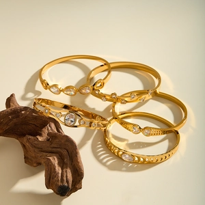 Detailed view of hollow geometric stainless steel bangles with sparkling zircon inlays