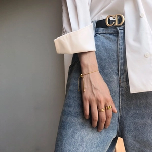 Bracciale a catena regolabile in oro con set di anelli minimalisti indossati dal modello