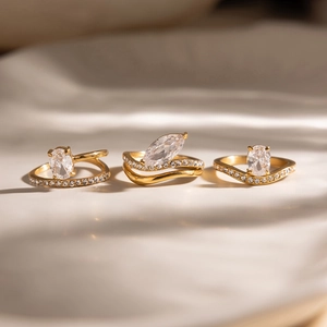 Dettaglio di tre anelli ondulati placcati in oro 18K con pietre marquise e ovali