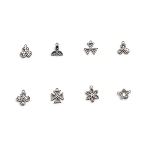 Selection of vintage stainless steel charms in various geometric and floral shapes