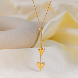 Elegante collana dorata con doppio ciondolo a cuore e catena a serpente su seta lucida