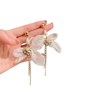 Elegant pearl fabric bow dangle earrings with gold tassels for a luxury vacation look.