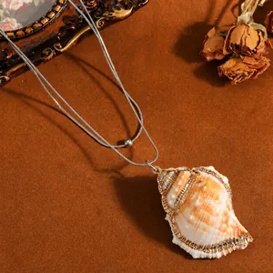 Close-up of a double-layer stainless steel necklace with gold-edged conch shell