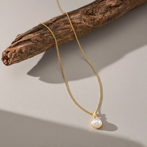 Collier élégant avec pendentif perle dorée et diamants sur une branche naturelle