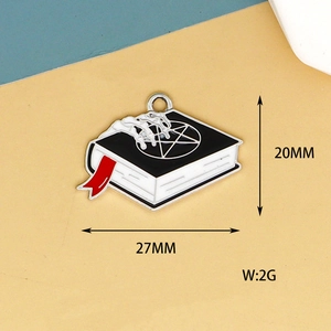 Vue détaillée macro d'un pendentif émaillé livre main de squelette Halloween 27mm