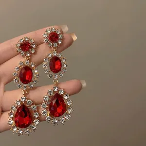 Vue rapprochée de boucles d'oreilles de style cour rétro avec pendentif goutte rouge