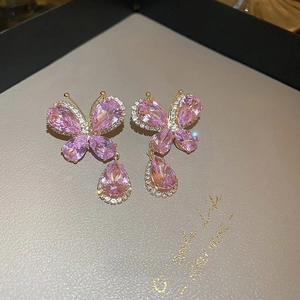 Détail de boucles d'oreilles papillon en cristal rose avec pendentifs gouttes d'eau