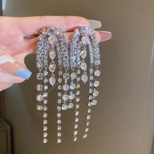 Gros plan de boucles d'oreilles à pompons argentées avec pierres en poire