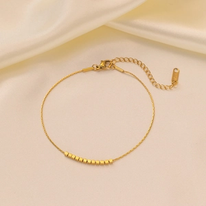 Minimalist gold titanium steel bracelet featuring ten square beads on a fine chain