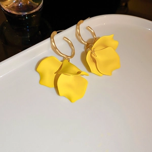 Vue détaillée de boucles d'oreilles pétales de fleurs jaunes avec anneaux dorés