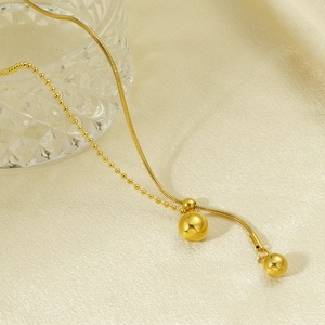 Collier ajustable à perles dorées avec chaîne serpent sur fond luxueux en velours