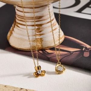 Primo piano di collane con ciondolo a fiore in oro con dettagli di design eleganti
