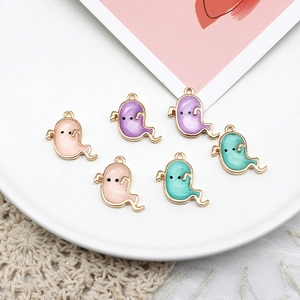 Close-up of DIY colorful Halloween ghost charms with elegant gold-edged enamel finish