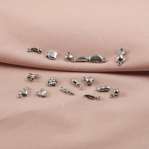 Detailed view of assorted stainless steel charms featuring heart, whale, and star shapes