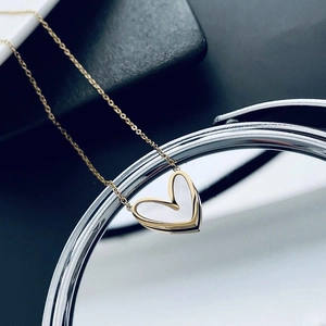 Collier minimaliste en or avec pendentif cœur nacré sur support miroir élégant