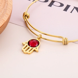 Gold stainless steel adjustable Hamsa hand bangle bracelet with faceted red crystal charm
