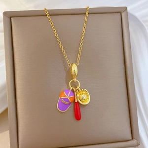 Détail d'un collier en acier titane avec pendentifs émaillés baseball, batte et gant