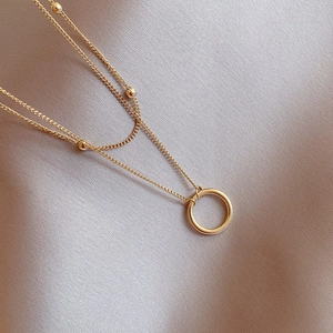 Elegant minimalist double-layer gold chain necklace featuring small beads and a round pendant