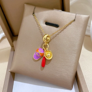 Gros plan détaillé d'un collier de baseball doré avec breloques chapeau, batte et gant.