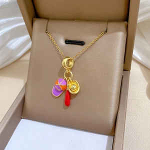 Détail du collier en acier titane doré avec pendentifs de baseball dans sa boîte cadeau
