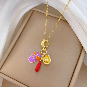 Vue détaillée du collier en acier titane avec breloques émaillées casquette, batte et gant
