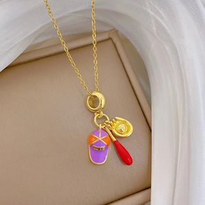 Gros plan d'un collier en acier titane doré avec des breloques de baseball en émail