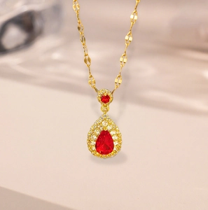Elegant gold necklace with a pear-cut red gemstone pendant and white crystal halo