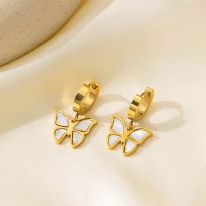 Elegante goldene Creolen mit Schmetterlingsanhängern aus weißem Perlmutt auf Seide