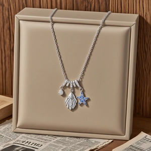 Silver starfish and shell pendant necklace with blue enamel on premium display