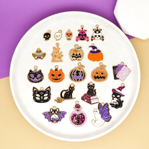 Detailed view of Halloween cartoon pumpkin and black cat alloy enamel charms on a white plate